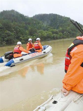 江西兴国曙光救援队在河里搜救。本报记者 何深宝摄