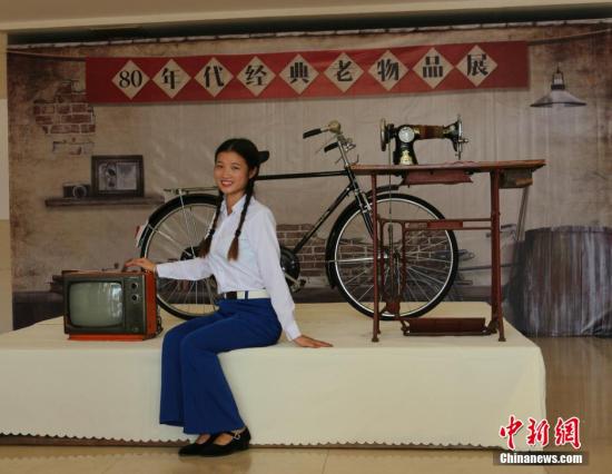 资料图 图为工作人员展示80年代的居家三件套： 永久自行车、黑白电视机、缝纫机 黄诗立 摄