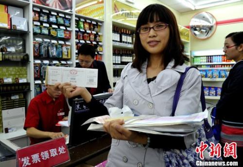 图为一位纳税人展示在超市刚领取的发票。<a target='_blank' href='http://www.chinanews.com/'>中新社</a>发 刘忠俊 摄