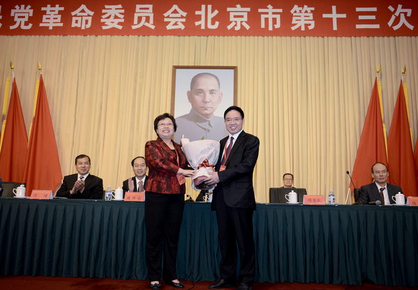 民革北京市第十五届委员会主任委员王红向民革北京市第十四届委员会主任委员傅惠民鲜花。17