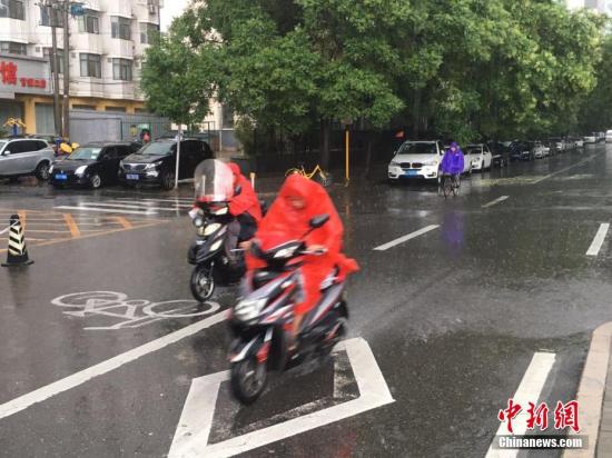 6月23日清晨，北京降雨持续，并出现了短时大雨。据北京市气象局官方微博消息，北京市气象台今日6时发布：今天白天小到中雨并伴有雷电，傍晚局地伴有短时大风或冰雹，北转东风2、3级，最高气温24℃；夜间有雷阵雨，东转北风2、3级，最低气温19℃。图为北京阜成路，市民雨中骑行。 <a target='_blank' href='http://www.chinanews.com/' >中新网</a>记者 富宇 摄
