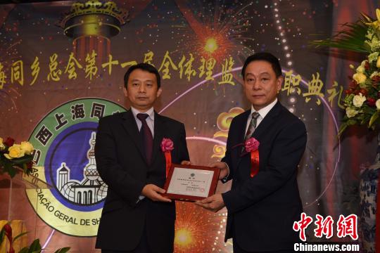 中国侨网图为中国驻圣保罗副总领事傅长华（左）为巴西上海同乡总会会长郑小云颁发任职证书。　莫成雄　摄