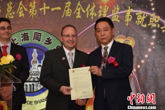 图为巴西圣保罗市政厅代表给巴西上海同乡总会会长郑小云(右一)递交贺信?！∧尚?摄