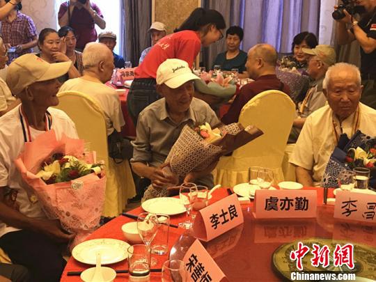 志愿者为抗战老兵献上鲜花?！⊙钛沾?摄