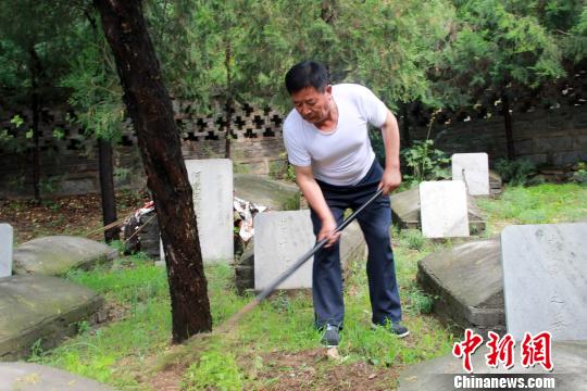 赵玉山在烈士墓园内锄草。　于俊亮 摄