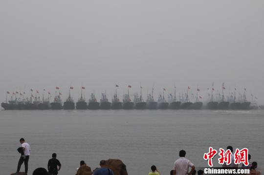 当地渔民驾驶着挂满红绸的渔船开启祭海巡游，驶向主祭坛所在地——海上碑龙王庙?！≌盼髦?摄