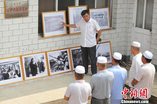 图为赵文岭在影展上向参观者介绍影展展出内容。　苑立伟 摄