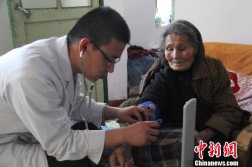 老人在接受血压检查。王子玮 摄