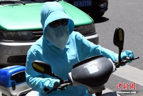 7月10日，福建省福州市民出行“全副武装”抵挡酷暑。刘可耕 摄