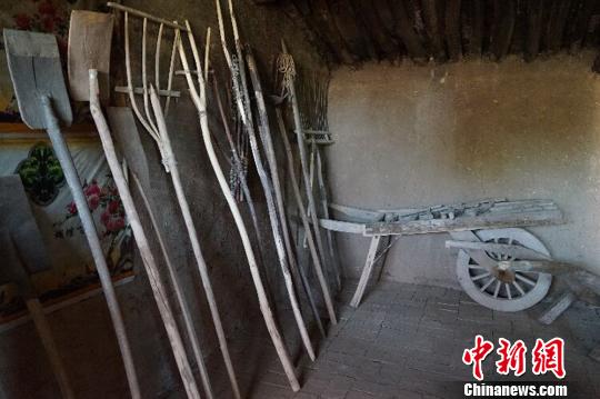 何世前的农家小屋里，整齐地陈列着年代不种的农具和生活用品?！〕滤?摄