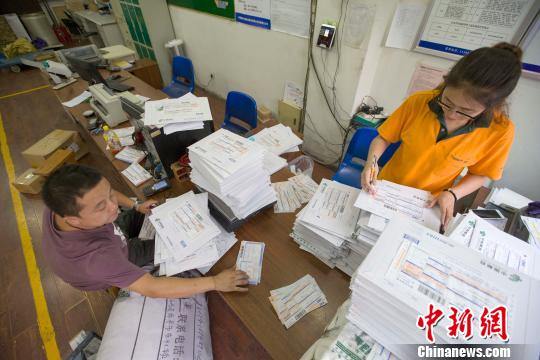 资料图：物流业工作人员正在录入快递信息?！≌旁?摄