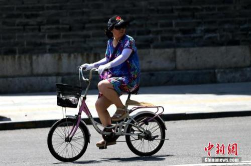 7月11日，陕西民众在烈日下出行。当日，陕西省气象台升级发布高温红色预警信号，未来24小时陕西大部分地区将出现37℃以上高温天气，局部地区将达40℃以上，未来四天还将会出现今年以来最强高温天气。 <a target='_blank' href='http://www.chinanews.com/'>中新社</a>记者 张远 摄