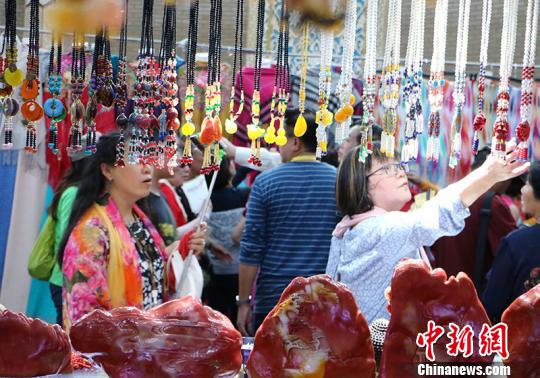 图为华教代表在观看民族特色工艺品。　耿丹丹 摄