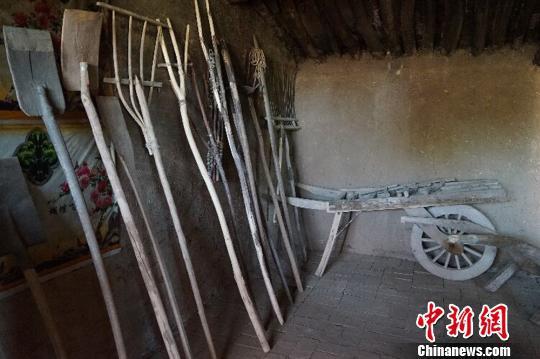 何世前的农家小屋里，整齐地陈列着年代不种的农具和生活用品?！〕滤?摄