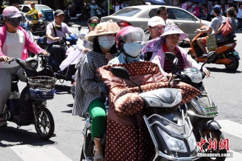 7月10日，福建省福州市民出行“全副武装”抵挡酷暑。 刘可耕 摄