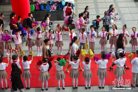 9月10日是一年一度的教师节。9月9日，山西太原新建路小学的教师们在学生们的欢呼簇拥下像明星一样走红毯展风采、秀签名，并接受他们崇高的敬礼与祝福。图为孩子们夹道欢迎老师走红毯展风采。张云 摄