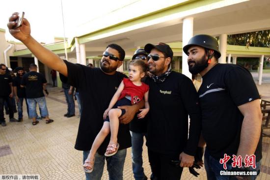 资料图为利比亚班加西摩托车手在穆斯林斋月期间看望孤儿院的儿童，并为他们带去礼物。