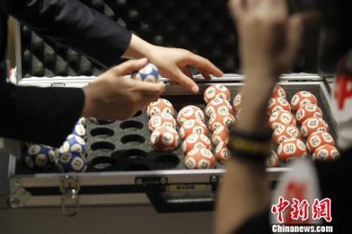 图为特制的开奖号码球，每个球重24克，价值1500元?！≈芫?摄