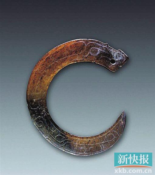 曲体玉龙 西周 陕西省长安县普渡村出土。器呈黄褐色，造型为“c”字形。头部较大，长眉，椭圆形长梢眼，口微张，鼻向上勾卷，器身弯曲状，由粗变细，尾呈尖状，向上勾卷，器身阴刻勾连云纹、眼目纹、二字纹等，口部镂空一小孔。此器造型是商代卷体玉龙的延续，但造型趋于平面化，背少雕脊齿，纹饰中少见重回纹及雷纹。相比商代，周代早期玉龙在雕刻技法和纹饰上有所变化。玉龙的嘴部、唇上翘并有角度。周初龙角也比商代小，但根部较大，躯体比商代瘦长，纹饰也较复杂化。西周中晚期，身躯更细长，无角，代替龙角的是花叶形耳朵，东周时出现卷云形耳。周代玉龙大多不雕刻腿和足。