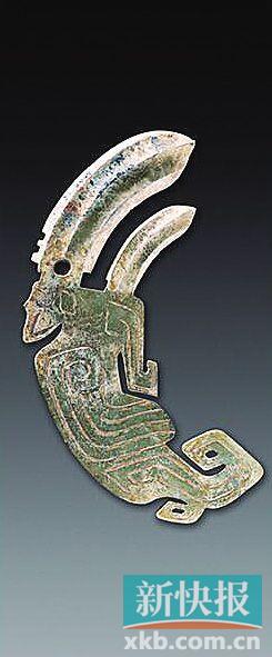 凤鸟形内双援玉戈 商 青玉，体扁平。凤鸟冠雕刻一大一小弯弧形援戈，中间有脊锋，前锋呈三角形，尖锐，两侧带刃，大援下部有扉棱和穿孔，可佩系。内为凤鸟身。凤鸟头后有角，棱形眼，尖喙，双翅并拢，尾部向上卷起，爪呈钩状，尾、足各有镂孔。翅膀用阴线雕刻，羽翎纹，两面纹饰相同。