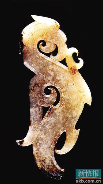 玉凤鸟佩 战国中期 河南省辉县固围村二号墓出土。器呈白色，上有黑色沁斑，尾端稍有残缺。体扁平，两面透雕成凤鸟形状，身成“s”形。俯首，张口，尖喙较长，并向内勾卷。圆圈形目，头顶有冠，身体较长，胸前部伸出一爪，较锋利，呈抓握状。背部雕有翅羽纹，分成两叉，一长一短，均向上呈卷曲状。尾部下垂。器身阴刻云纹、曲线纹等。战国时期，雕刻有大量的精美龙形佩饰，此器的造型与龙形佩有相似之处，但在喙、冠、翅、爪及纹饰上又有着独特韵味，更显生动鲜活。