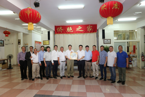 冯志农向法国华侨华人会赠送纪念品。