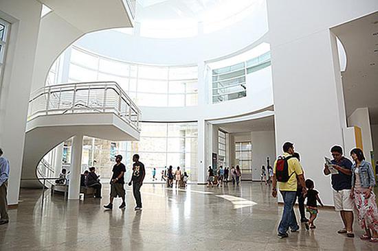 阳光透过博物馆入口大厅的玻璃外墙照射进来，为室内提供照明。