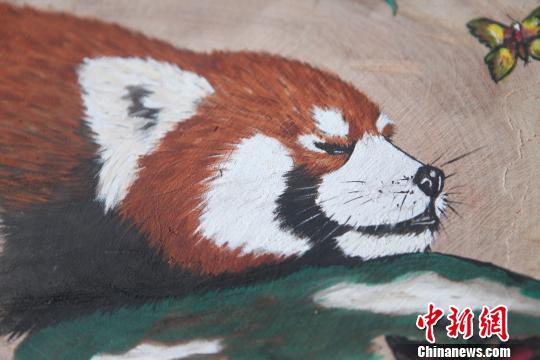 图为珞碧迈创作的4副“嘟嘟”圆木板画像?！≈有?摄