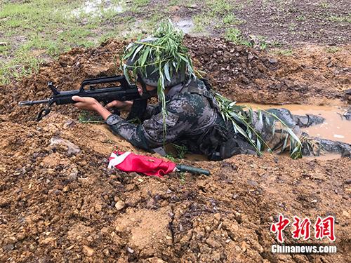 战士趴在水坑里演练 张曦 摄