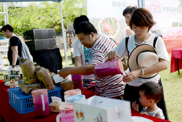 22.各地来到集旅游和休闲结合的大丘庄园游览的游客，在这里品尝火龙果汁。jpg