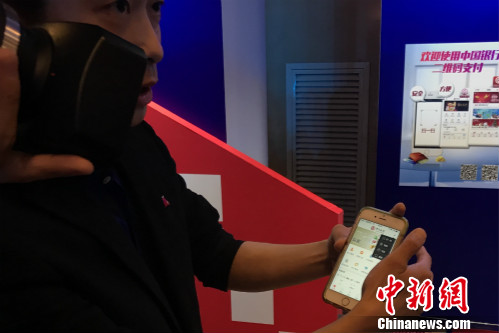 一位工作人员正在教体验者使用云闪付产品。<a target='_blank' href='http://www.chinanews.com/' >中新网</a> 种卿 摄