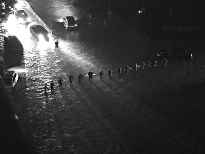 暴雨中，抢险队员站成“人墙”，引导交通。刘瑜摄 