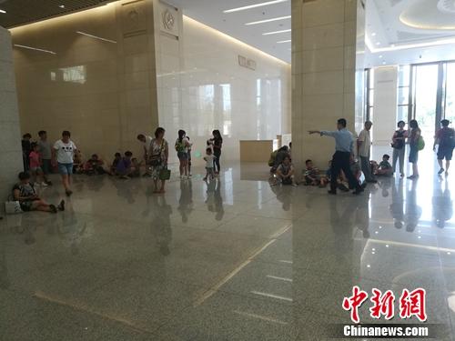 军博一层大厅也有一些参观者坐在地上，工作人员正在劝他们不要席地而坐。上官云 摄