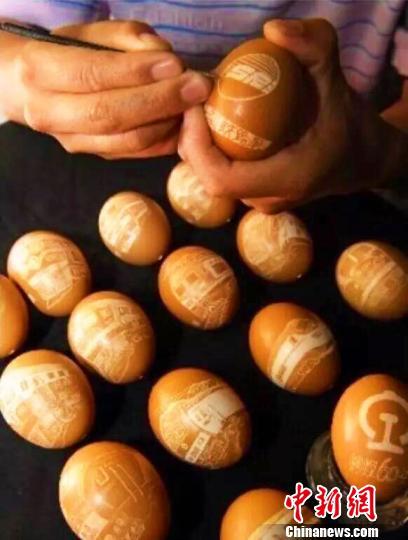 王剑用刻刀在蛋壳上记录中国铁路事业发展。　钟欣 摄