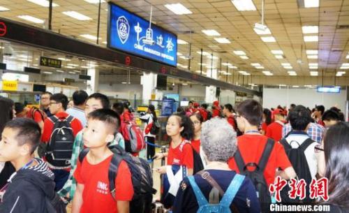 皇岗边检站增开通道快速为前往新加坡游学返程的三百余名广西柳州的小学、中学生旅游团办理入境手续?！』瓶∩?摄