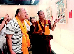     中国工艺美术大师和国家级非物质文化遗产代表性传承人更登达吉（右）向来宾介绍展品。