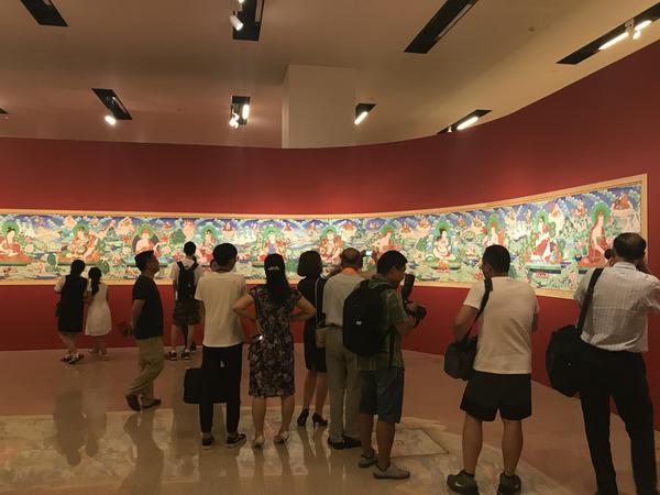 观众们正在欣赏两代唐卡画师合作的30米长卷