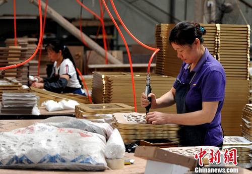 7月17日，中国国家统计局发布的数据显示，上半年，中国居民人均可支配收入12932元人民币，扣除价格因素实际增长7.3%，增速比一季度加快0.3个百分点，比上年同期加快0.8个百分点；GDP同比增长6.9%，低于居民人均可支配收入增长0.4个百分点。图为厦门一企业生产车间，工人正在流水线上作业。(资料图片) <a target='_blank' href='http://www.chinanews.com/'>中新社</a>记者 张斌 摄