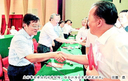 光彩事业凉山行活动现场，徐乐江为企业家颁发证书。  张雷  摄