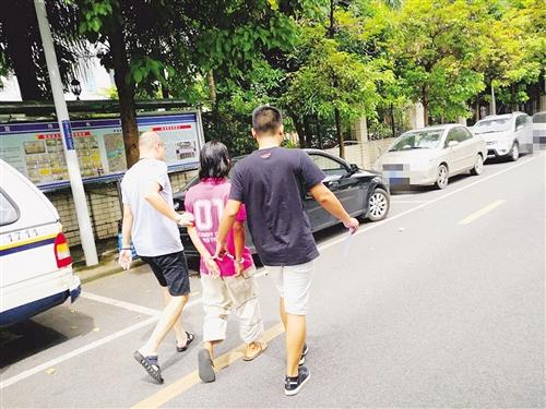 男子(中)被警方带去指认现场 本报记者 潘国武 摄