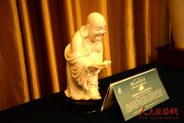 图为现场展出的德化白瓷作品：瓷塑《引福归堂》。