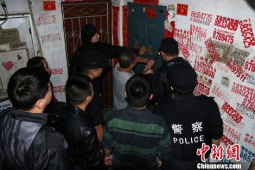 资料图：2016年11月19日，福建延平，民警用撬棍撬开传销窝点防盗门。　丁晨 摄