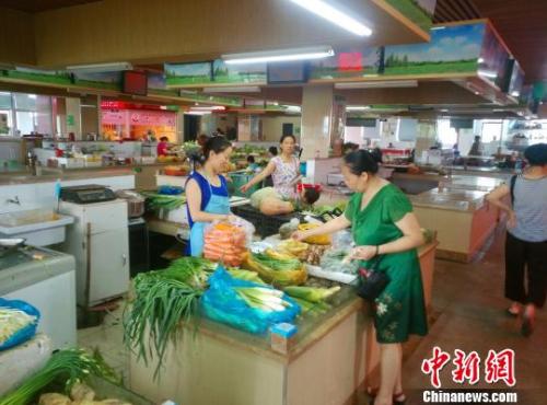 资料图：民众正在菜场挑选蔬菜水果。　赵侃一 摄