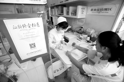 昨天，西单献血小屋内，一名前来无偿献血的女子正在接受化验。这里平常日均献血人数有20至30人，暑期以来，每天降至10至15人。 实习记者 武亦彬摄