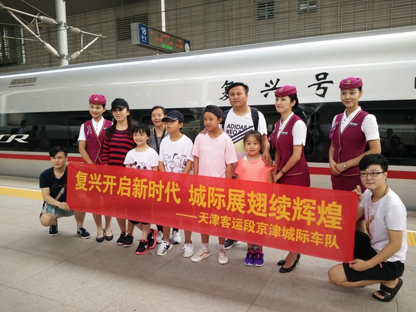 京津城际迎来“复兴号“，旅客与乘务员合影留念