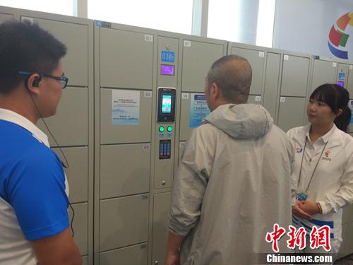 志愿者帮助记者使用电子储物柜。