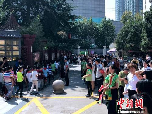 图为学校门口挤满了学生家长?！∶凤钽?摄