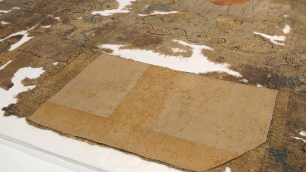 修复师们留下了这一片修复布料，以作为20世纪早期修复工作的一份记录