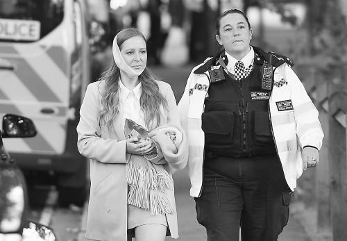 英国安全人员陪同伤者离开爆炸现场。