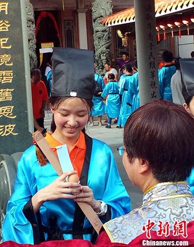 9月22日至24日，由马祖县政府与厦门陆岛旅游投资有限公司联合举办的两岸成年礼活动在马祖举行。来自福州、厦门、龙岩和马祖的260多位两岸学子参加活动。图为9月23日下午，马祖牛角五灵公庙前，“做出幼”作为本届两岸成年礼系列活动之一隆重举行。仪式上，身着汉服的马祖高中生，由长辈加冠，吃平安蛋，饮成年酒。 <a target='_blank' href='http://www.chinanews.com/'>中新社</a>记者 邢利宇 摄